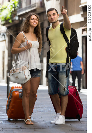 Travelers with baggage in the street Travelers with baggage in the street 11928836