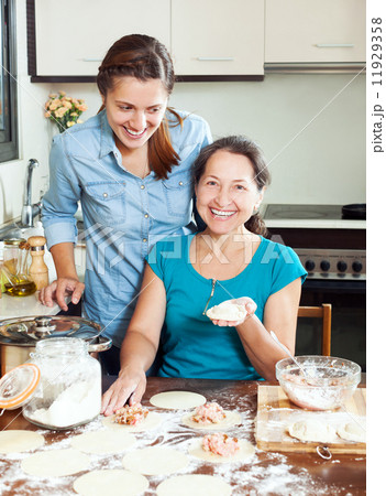 cooking mother with adult daughter 11929358
