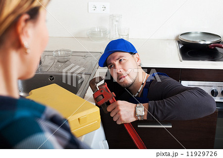 Woman watching as plumber working 11929726