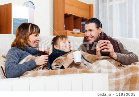 Happy parents and son warming near warm heater 11930005