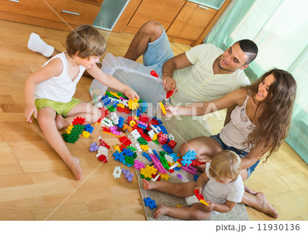Family of four at home with toys Family of four at home with toys 11930136