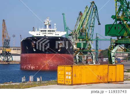 Big industrial cargo ship and yellow container stand in port Big industrial cargo ship and yellow container stand in port 11933743