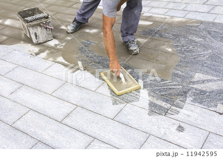 Grouting tiles on the floor 11942595