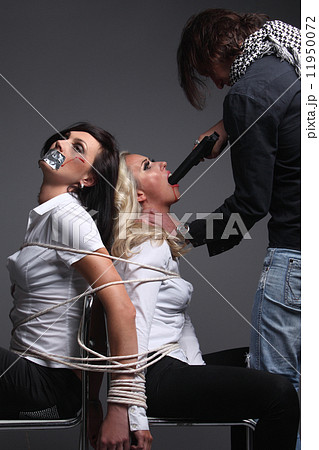 Crime. Two beautiful girls in the Business clothing kidnapped by criminals. Terrorist is threatening 11950072