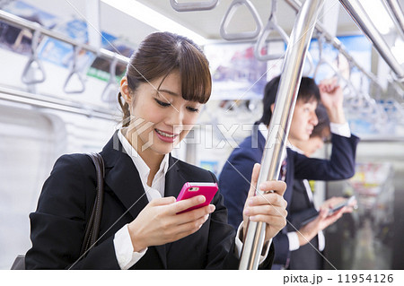 電車内でスマホを操作する女性の写真素材