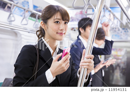 電車内でスマホを操作する女性の写真素材