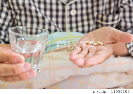 薬を飲むシニア男性患者 11959109