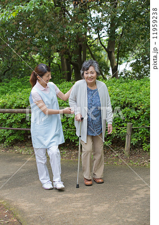 シニア女性の歩行を介助する介護福祉士 11959238