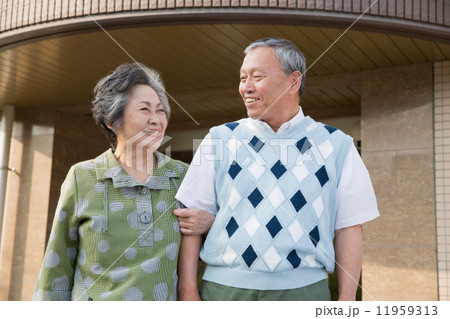 病院の前に並んで立つシニア夫婦 11959313
