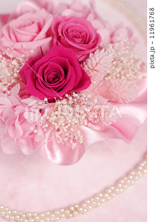 バラのプリザーブドフラワー ピンク背景 円パール 縦の写真素材