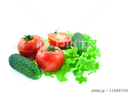 two and half tomatos and two cucumbers on leaves of lettuce 11980720