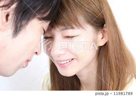 額をくっつけ目を閉じた若い夫婦（カップル） 11981789