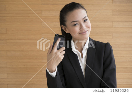 Asian Business Woman Indoor with mobile telephone Asian Business Woman Indoor with mobile telephone 11989326