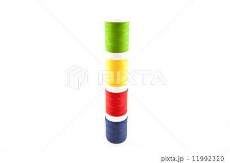 four multicolored spools on a white background four multicolored spools on a white background 11992320