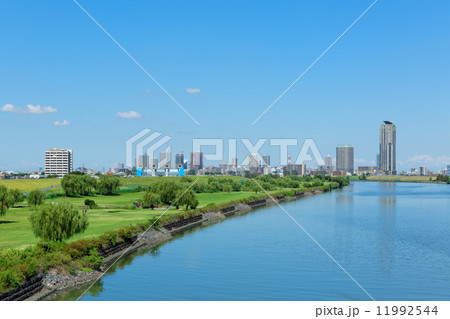 青空が広がる荒川河川敷の都民ゴルフ場と川口元郷の高層住宅街 11992544