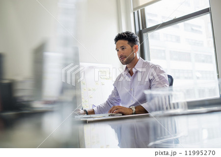 Office life. A man working alone in an office. 11995270