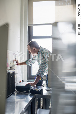 Office life. A man standing up working and making notes on a wall chart. Project management. 11995276