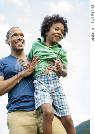 A man lifting his son up in his arms, playing outdoors. A man lifting his son up in his arms, playing outdoors. 11995442