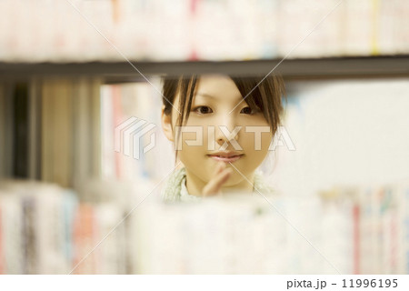 図書館で本を選ぶ女性 11996195