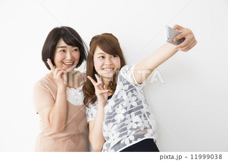 スマホで写真を撮る仲良し母娘 11999038