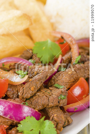 Lomo Saltado - Traditional Peruvian stir-fry with beef, red onions, tomatoes and fries 11999070