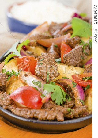 Lomo Saltado - Traditional Peruvian stir-fry with beef, red onions, tomatoes and fries 11999073