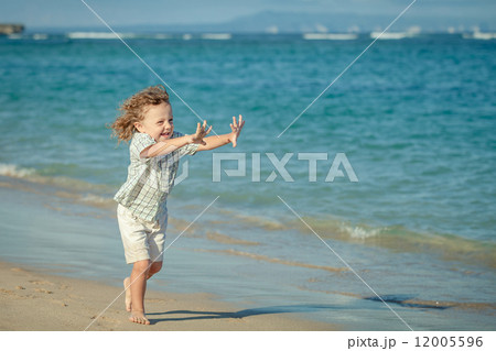 little boy running on the beach in the day time little boy running on the beach in the day time 12005596
