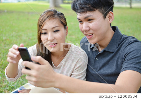 Young couple looks at mobile phone 12008534