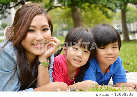 Mother and kids lay on the grass Mother and kids lay on the grass 12008538