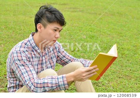 Young man reads book in the garden 12008539