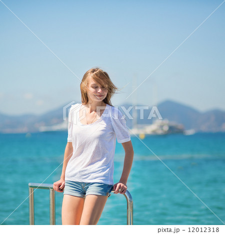 Beautiful girl enjoying her vacation by the sea Beautiful girl enjoying her vacation by the sea 12012318