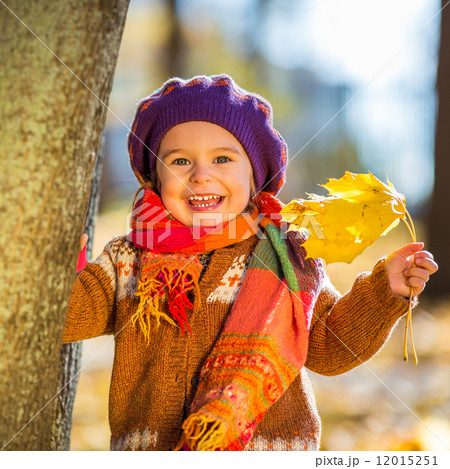 Happy little girl playing in the autumn park 12015251