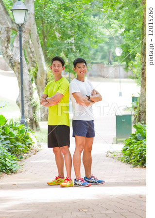 Men Standing with Folded Arms in the Park 12015260