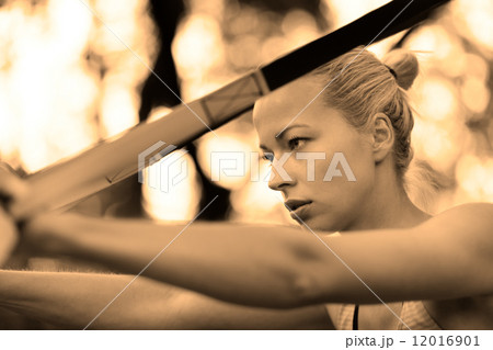 Training with fitness straps outdoors. 12016901