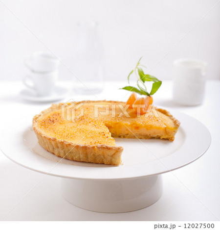 Tangerine creme brulee tart on a white background 12027500