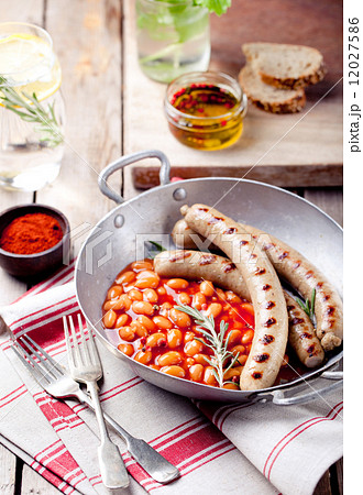Grilled sausages with beans in tomato sauce 12027586