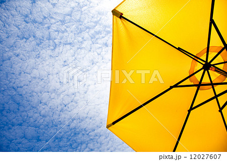 Yellow sun umbrella on a blue sky. 12027607