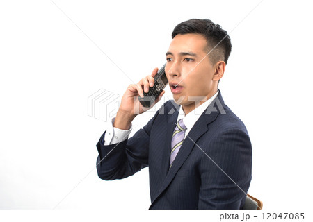 驚いて電話している日本人男性ビジネスマン 驚いて電話している日本人男性ビジネスマン 12047085