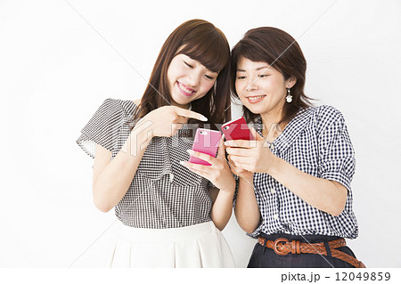 スマホを見せ合う母娘の写真素材