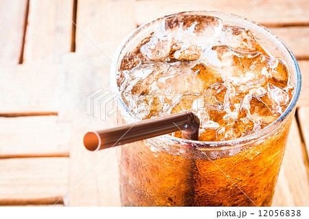 Fresh cola drink with ice on wood table Fresh cola drink with ice on wood table 12056838