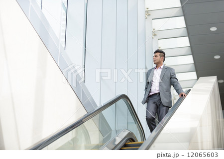 One successful young Malay business man talking the escalator One successful young Malay business man talking the escalator 12065603