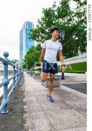 Young asian man stretching before exercise in the city 12067749