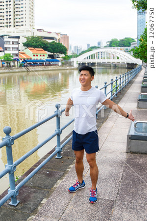 Young asian man stretching before exercise in the city Young asian man stretching before exercise in the city 12067750