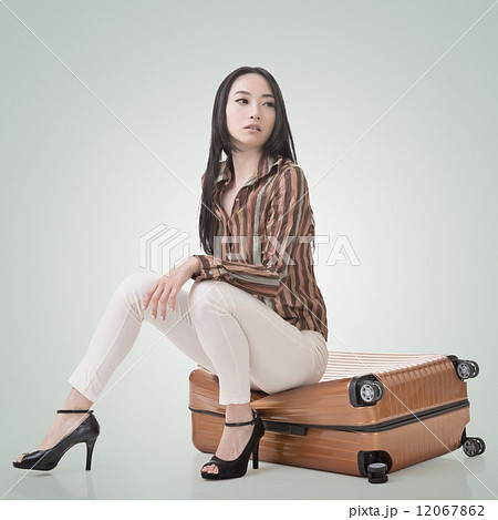 Asian woman thinking and sitting on a luggage 12067862