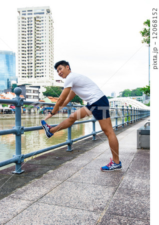 Young Asian male doing stretching / exercising outdoor in the city 12068152