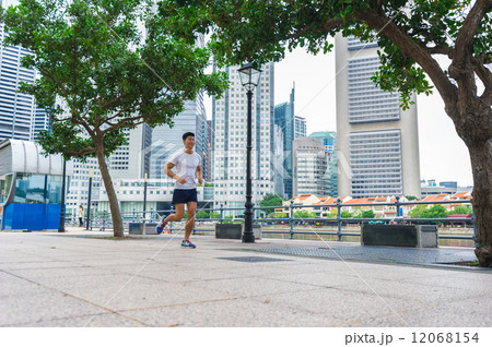 Young Asian male doing stretching / exercising outdoor in the city 12068154