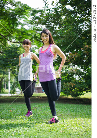 Two young beautiful asian ladies exercising / doing yoga in the park 12072832