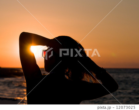 Silhouette of the woman standing at the beach 12073025