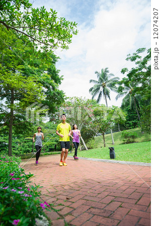one asian male and two asian ladies jogging in the park one asian male and two asian ladies jogging in the park 12074207