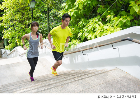 A young asian couple working out through climbing the stairways outdoor 12074241